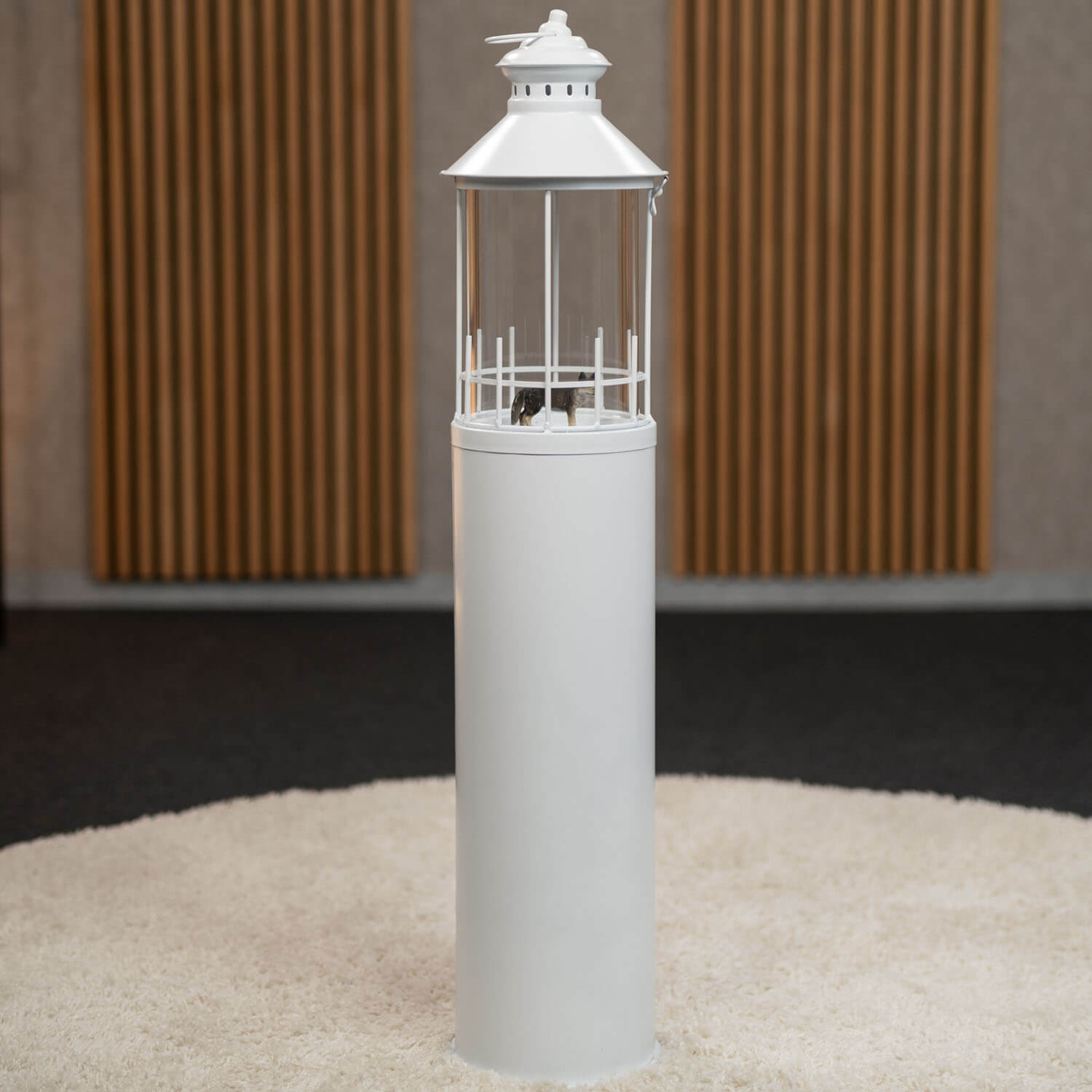 Wolffigur steht in einer Laterne, die aussieht wie ein Leuchtturm